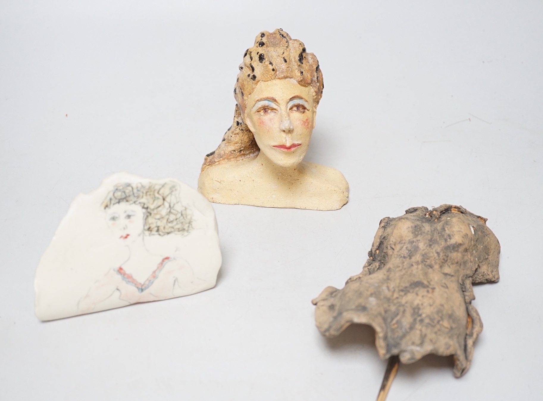 Coral Pearson-Revel (New Zealander) - Three works - A painted terracotta head and shoulders of a woman; a terracotta woman’s torso, dated 2007 and a half circle plaque, painted with a bust of a woman, each signed